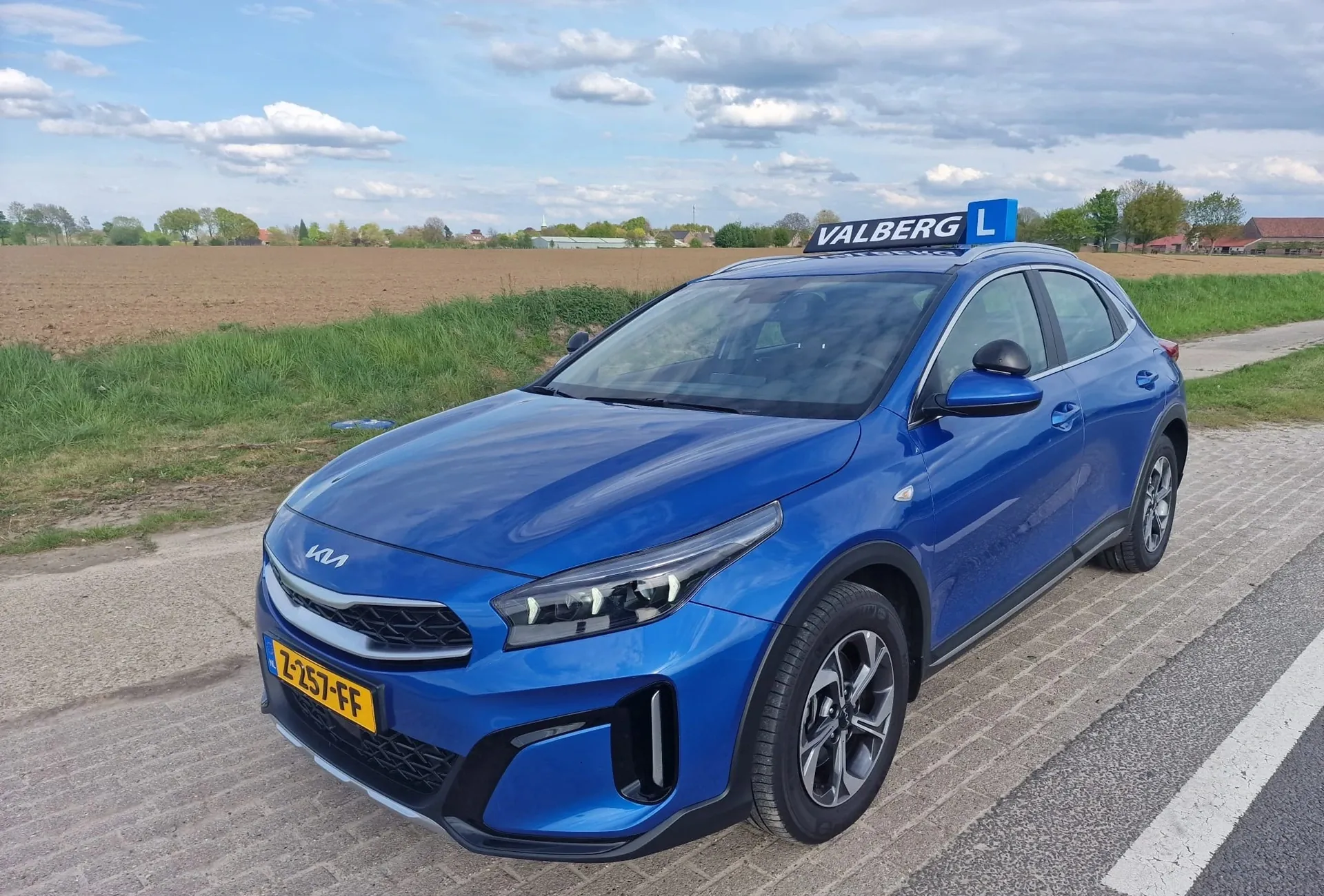 Blauwe lesauto van Autorijschool Valberg langs de weg in Valkenburg